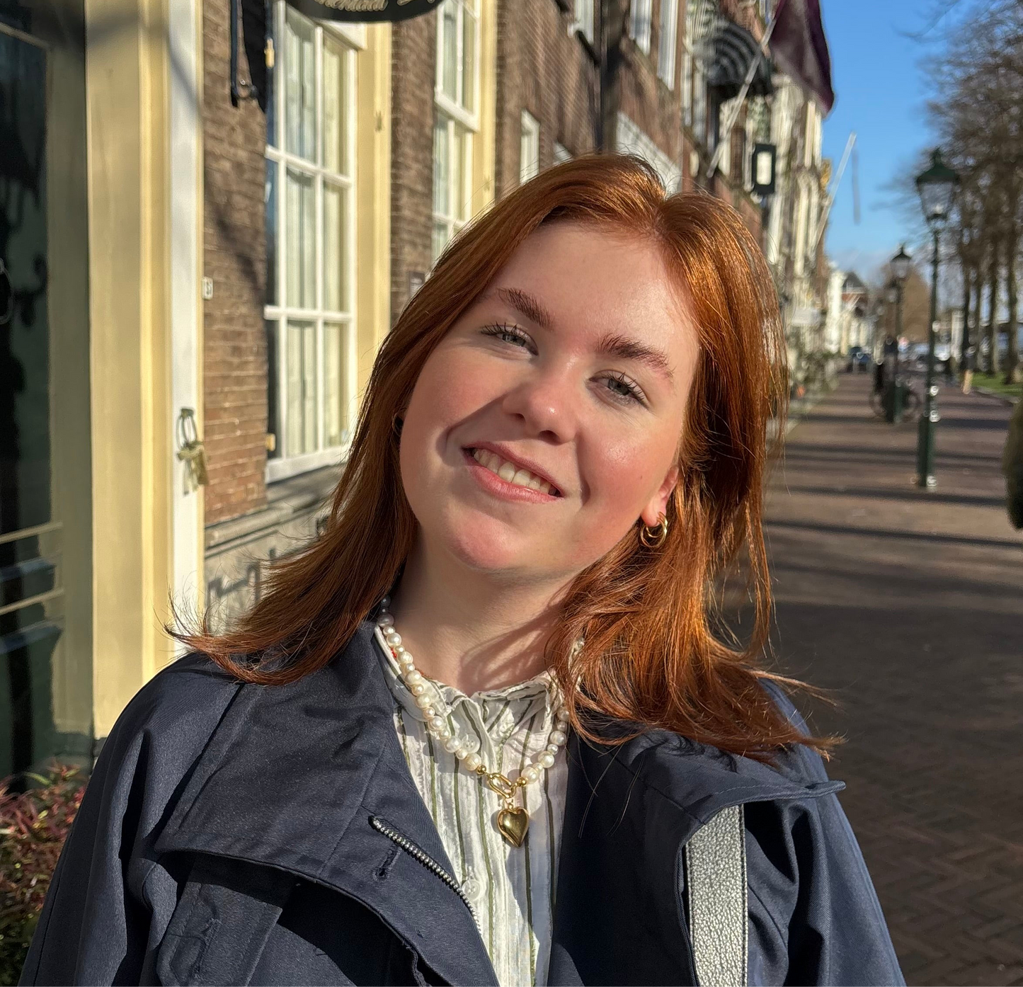 vrouw met witte parelketting met hart bedel