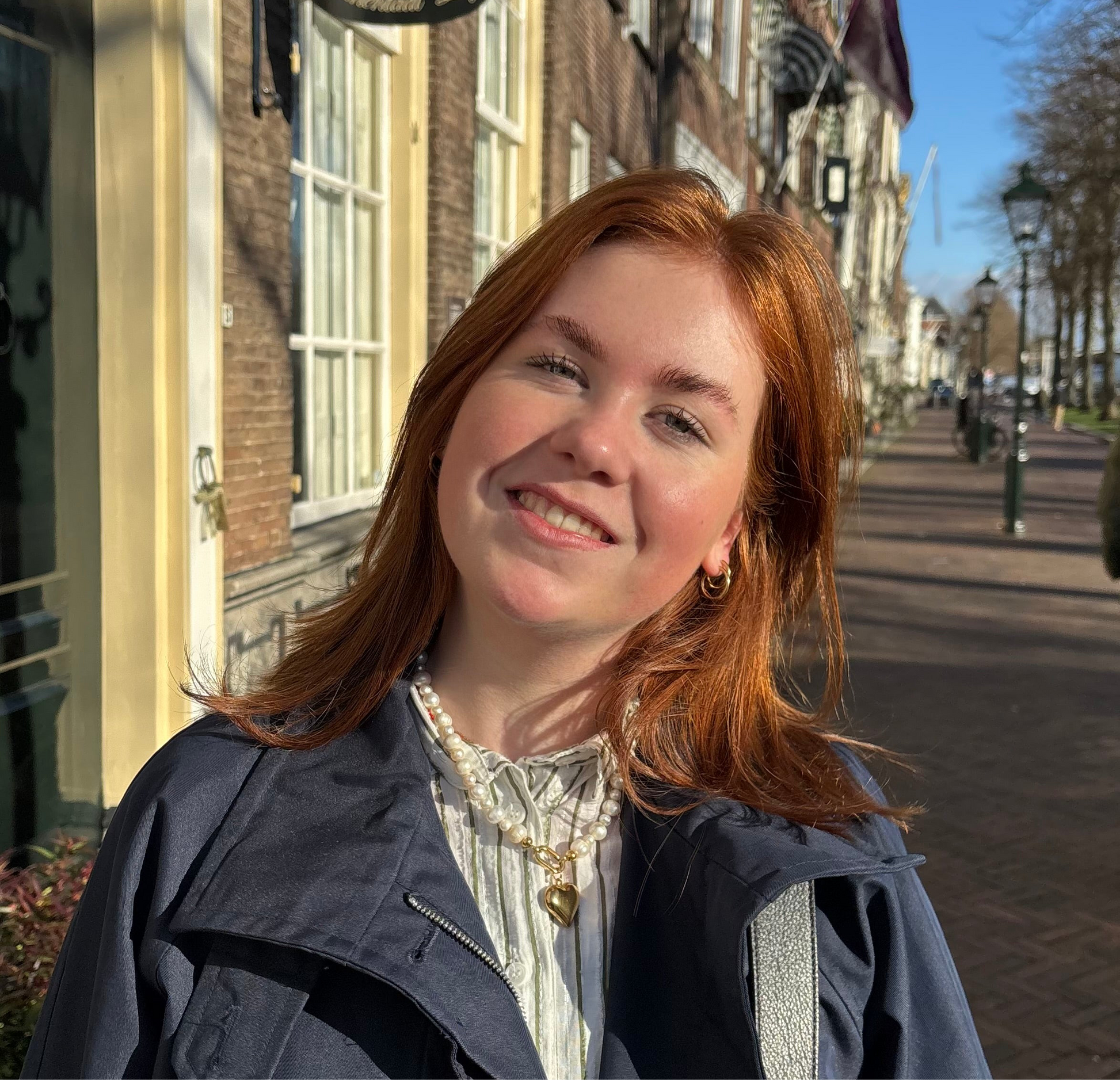 vrouw met witte parelketting met hart bedel