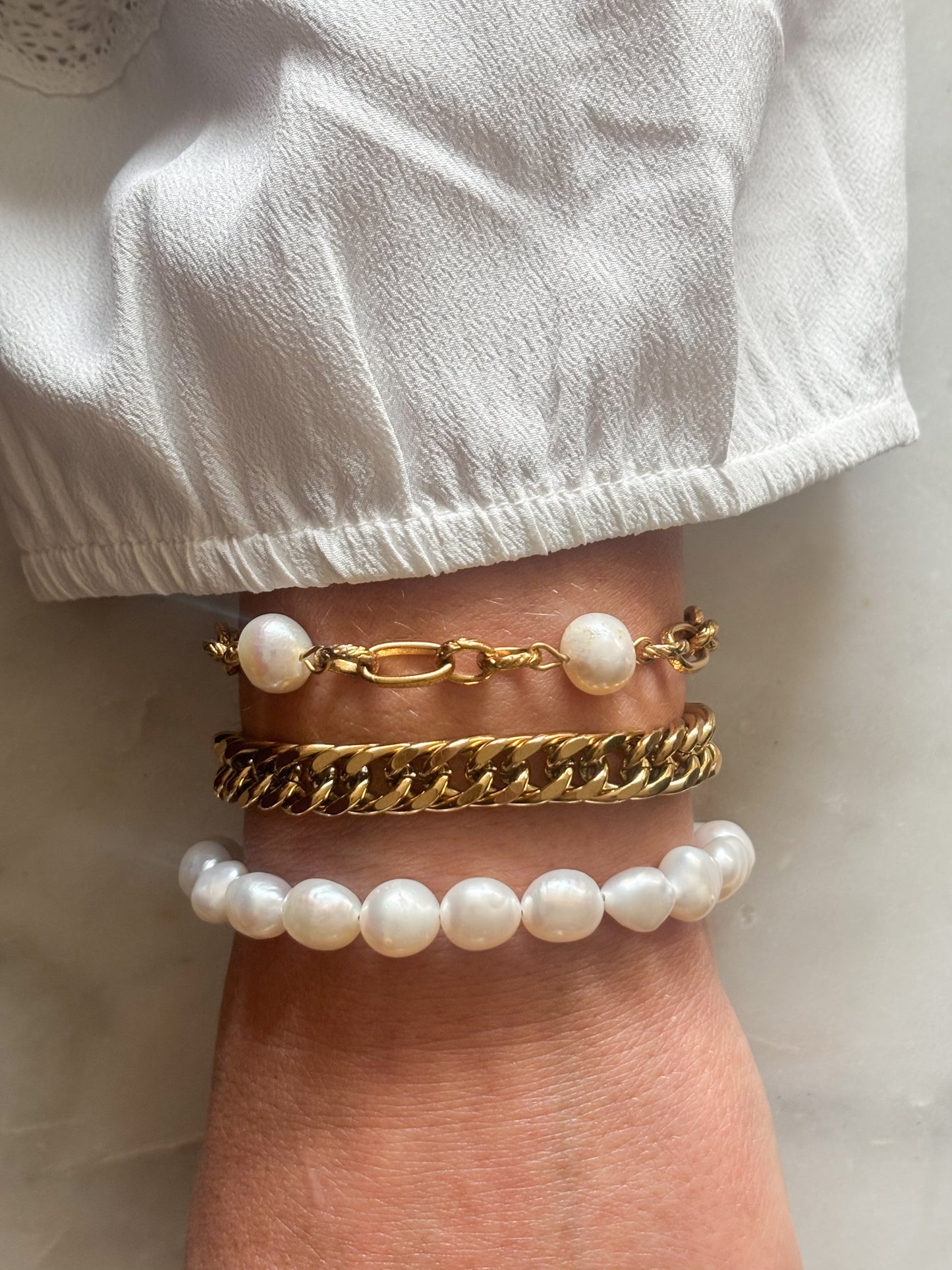 Pols met gouden rvs parel armbanden 